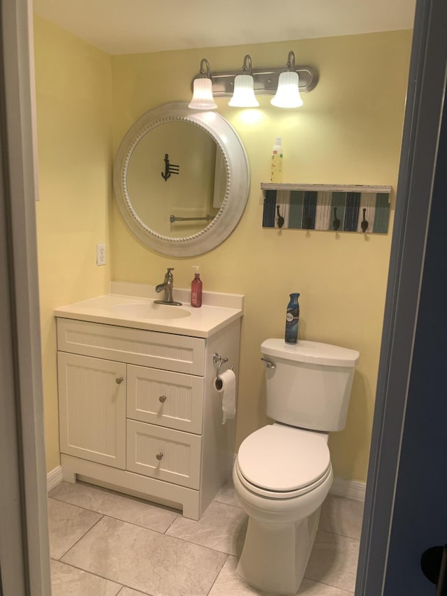 bathroom with tile patterned flooring, toilet, vanity, and baseboards