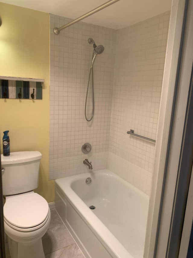 bathroom featuring toilet, baseboards, and shower / bathtub combination