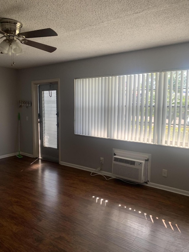 entrance foyer with a ceiling fan, wood finished floors, baseboards, a wall mounted AC, and a textured ceiling