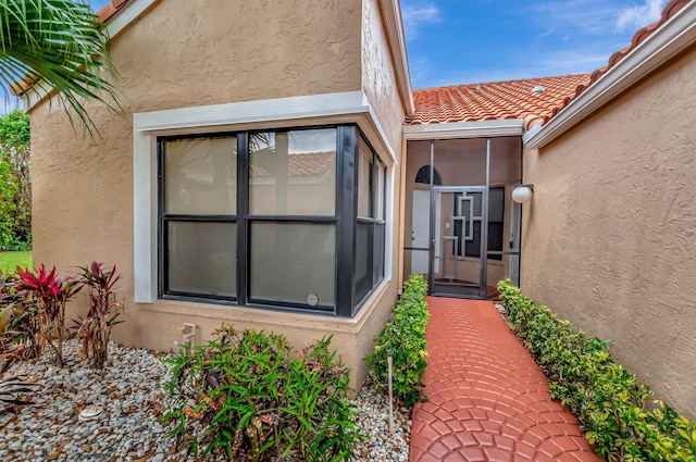 property entrance featuring stucco siding and a tiled roof