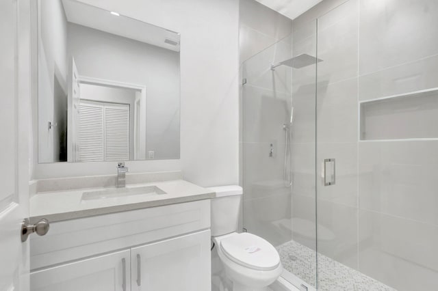 bathroom with a shower stall, toilet, and vanity