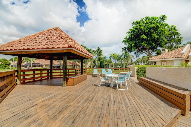 wooden terrace with a gazebo and outdoor dining area