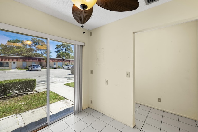 entryway featuring light tile patterned floors, baseboards, a textured ceiling, and a ceiling fan