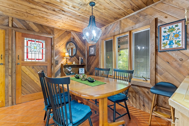 dining area with an inviting chandelier, wooden walls, wood ceiling, and tile patterned floors