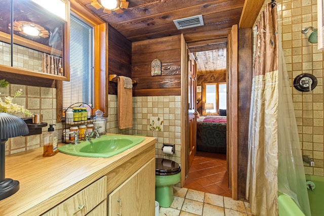 ensuite bathroom featuring vanity, visible vents, wood ceiling, shower / bath combo with shower curtain, and toilet