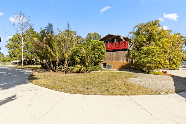 view of front of home with central AC unit and a front yard