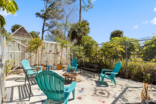 view of patio featuring a fire pit and fence