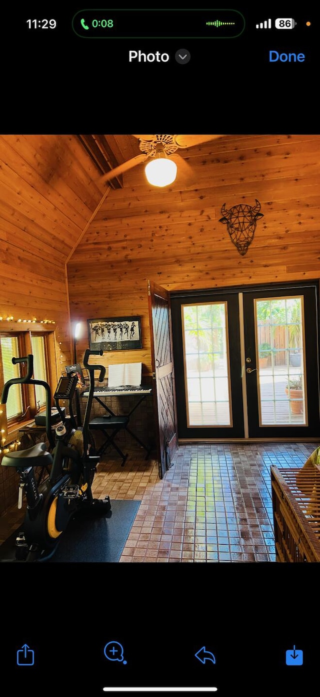 interior space with beam ceiling, wooden walls, and high vaulted ceiling