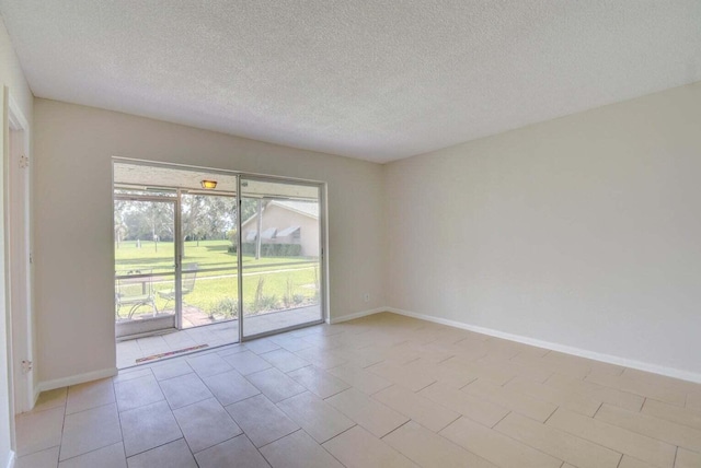 empty room featuring baseboards and a textured ceiling