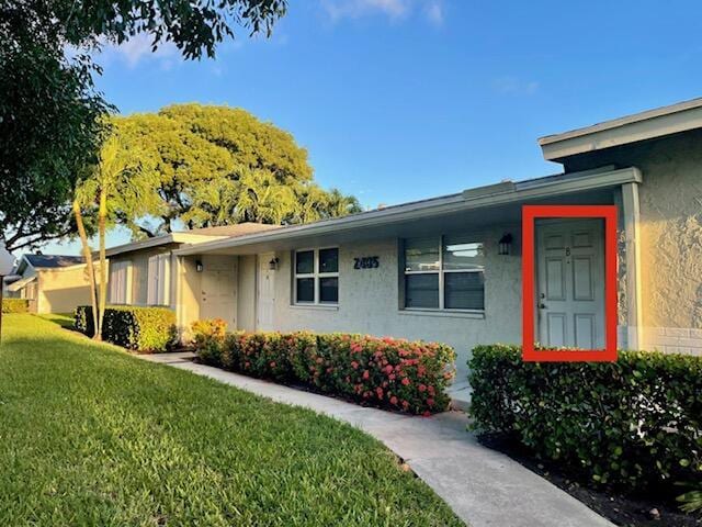 single story home with a front yard and stucco siding