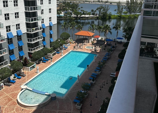 pool featuring a patio area and a water view