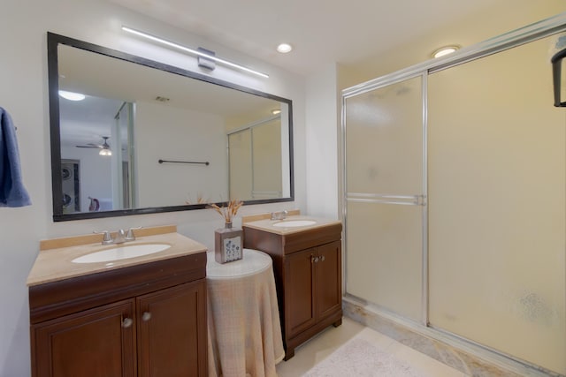 full bathroom with a shower stall, two vanities, ceiling fan, and a sink