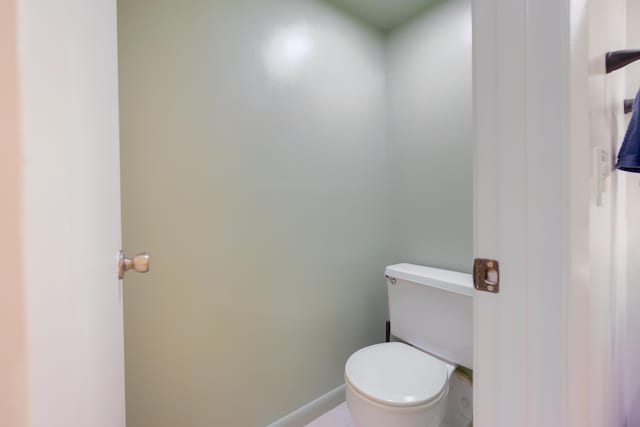 bathroom with toilet and baseboards