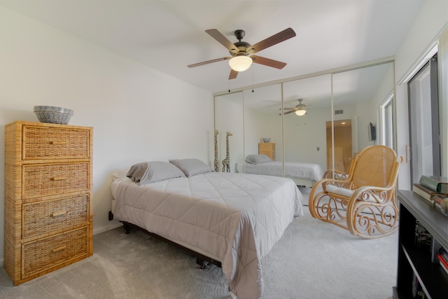 carpeted bedroom featuring visible vents, a closet, and a ceiling fan