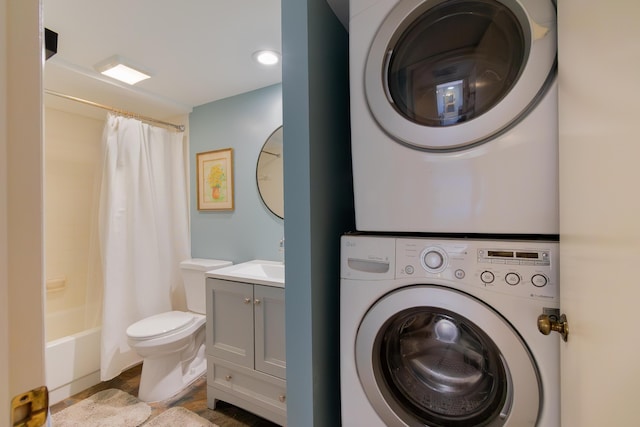 laundry area with a sink, laundry area, and stacked washer / dryer