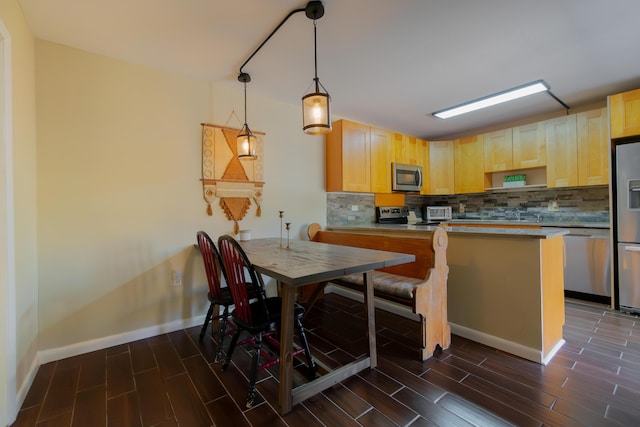 kitchen with tasteful backsplash, light brown cabinets, stainless steel appliances, and wood finish floors