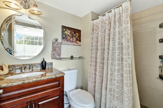 bathroom featuring a shower with curtain, toilet, and vanity