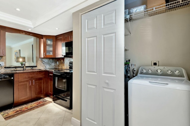 washroom with ornamental molding, laundry area, washer / dryer, light tile patterned flooring, and a sink