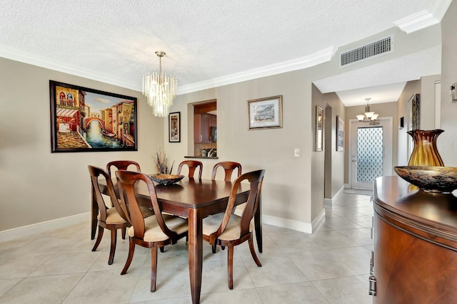 dining room with visible vents, ornamental molding, light tile patterned floors, a notable chandelier, and a textured ceiling