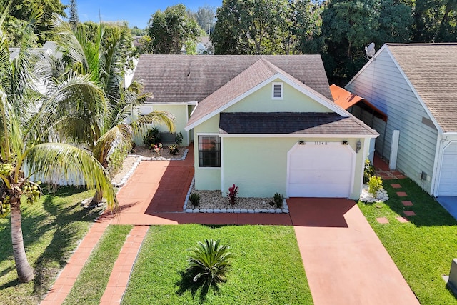 view of front facade featuring roof with shingles, concrete driveway, and a front yard