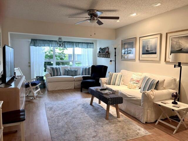 living room featuring a ceiling fan, recessed lighting, wood finished floors, and a textured ceiling