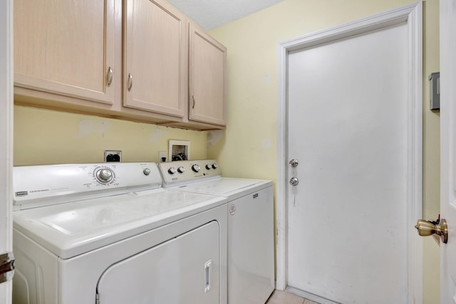 clothes washing area featuring washer and clothes dryer and cabinet space