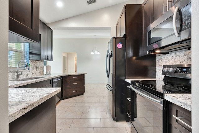 kitchen featuring light stone countertops, a sink, stainless steel appliances, vaulted ceiling, and dark brown cabinetry