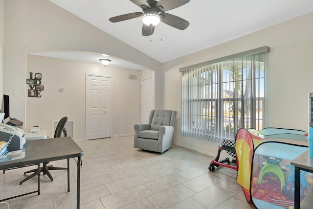 home office with baseboards, visible vents, arched walkways, ceiling fan, and vaulted ceiling