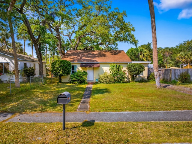 view of front of home featuring stucco siding, a front yard, and fence