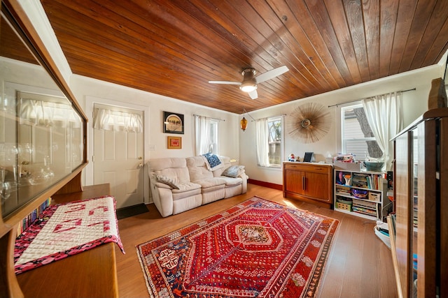 living room with a ceiling fan, wooden ceiling, wood finished floors, and ornamental molding