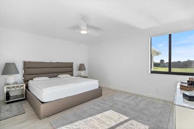 bedroom featuring baseboards, light wood-type flooring, and ceiling fan