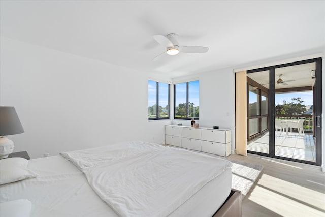 bedroom with light wood-type flooring, multiple windows, a ceiling fan, and access to outside