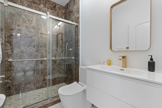 bathroom with vanity, a shower stall, and toilet