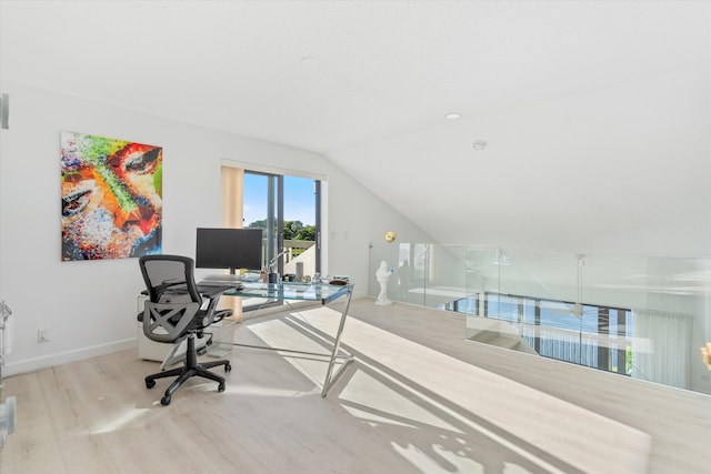 home office featuring lofted ceiling, wood finished floors, and baseboards