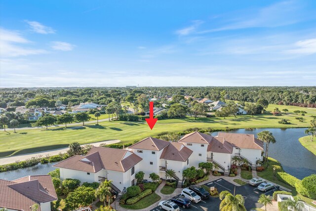 aerial view with view of golf course, a water view, and a residential view