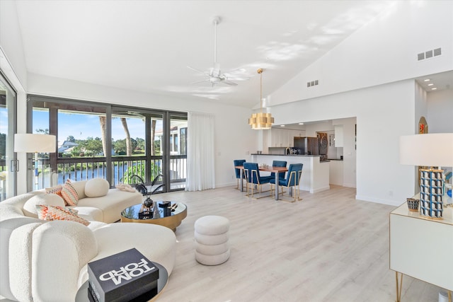 living room with visible vents, high vaulted ceiling, light wood-type flooring, and ceiling fan