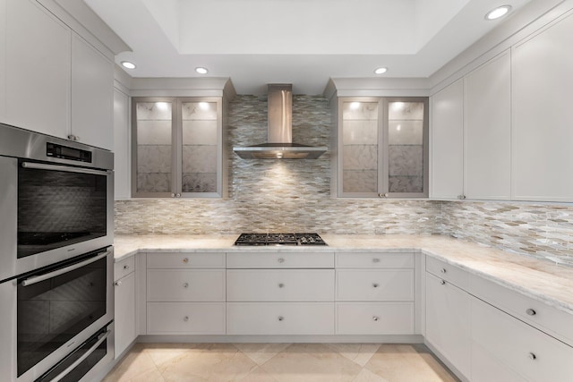 kitchen with decorative backsplash, wall chimney range hood, recessed lighting, and appliances with stainless steel finishes