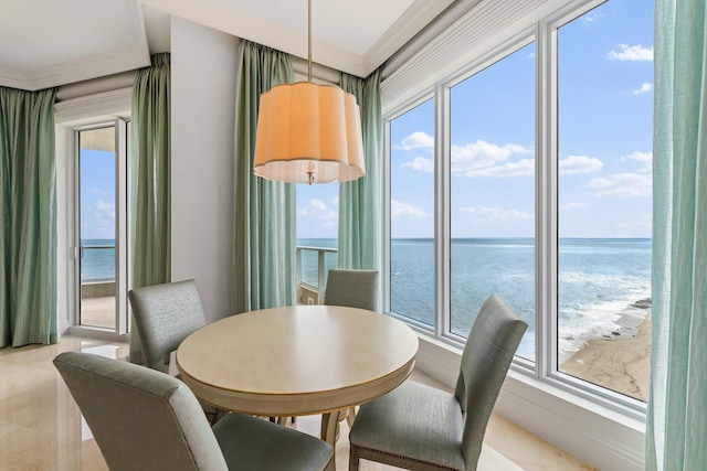 dining room featuring crown molding and a water view