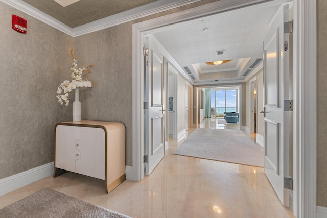 corridor featuring wallpapered walls, baseboards, a tray ceiling, ornamental molding, and marble finish floor