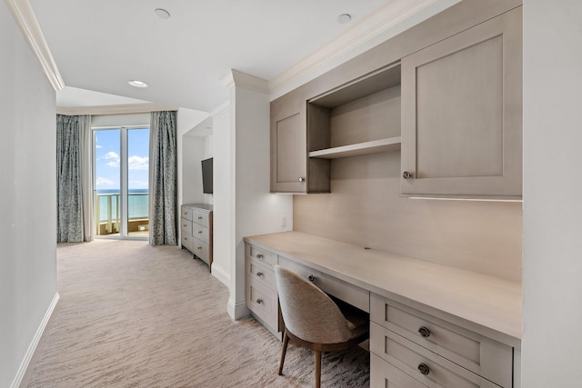 home office featuring built in desk, light colored carpet, crown molding, and baseboards