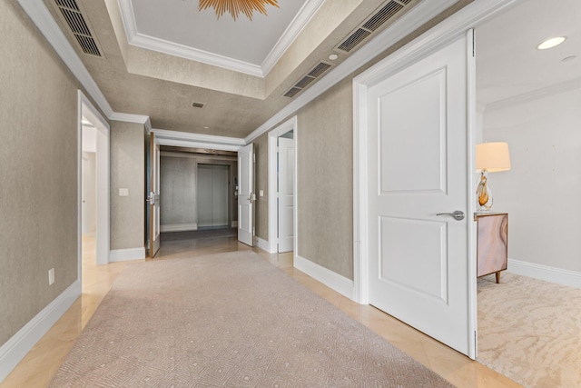 corridor featuring a tray ceiling, visible vents, and ornamental molding