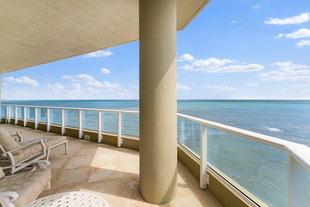 balcony featuring a water view and baseboard heating