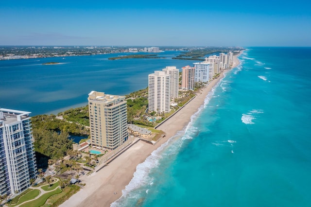 drone / aerial view featuring a view of city, a beach view, and a water view