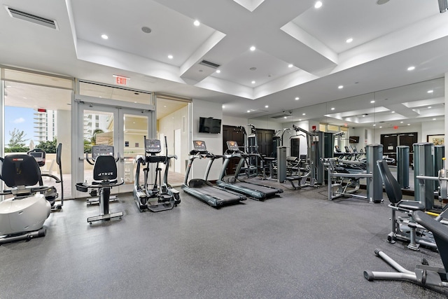 gym with a tray ceiling, visible vents, recessed lighting, and french doors