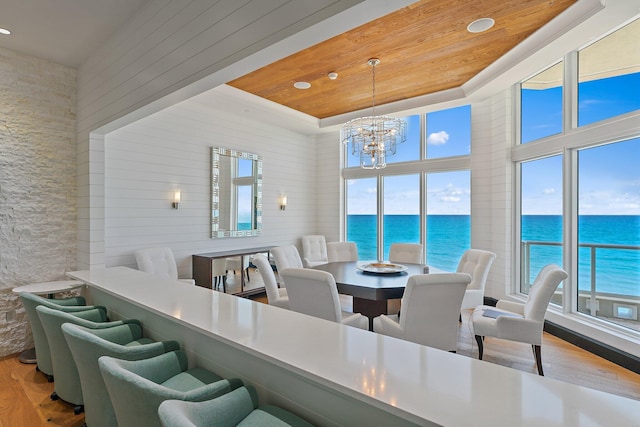 dining space with a wealth of natural light, a chandelier, wooden ceiling, and wood finished floors