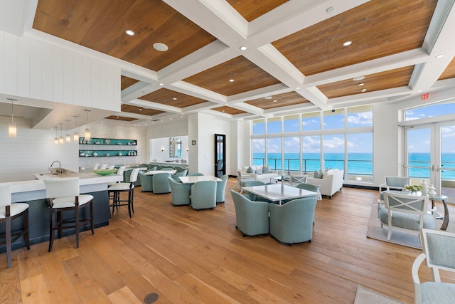 living room with a water view, coffered ceiling, light wood-style flooring, and wooden ceiling