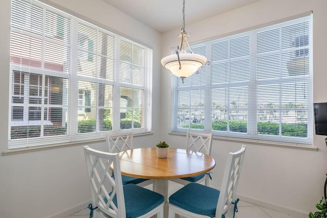 tiled dining area with a healthy amount of sunlight and baseboards