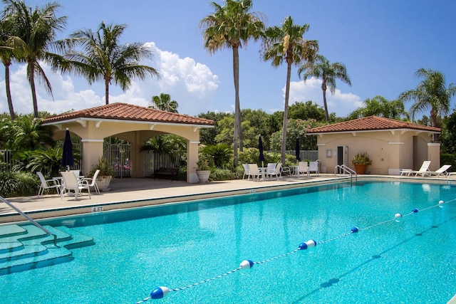 community pool featuring a patio area and fence