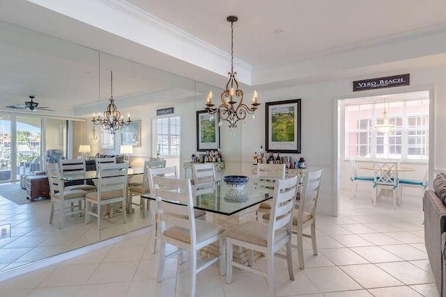 dining space featuring light tile patterned floors, a healthy amount of sunlight, and a raised ceiling