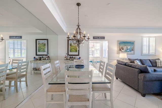 dining room featuring a raised ceiling, plenty of natural light, light tile patterned flooring, and crown molding